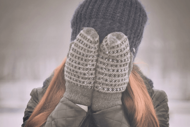 Woman wearing mittens in the cold to stay warm