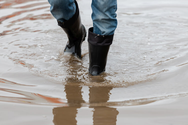 Walking in water in waterproof rubber boots