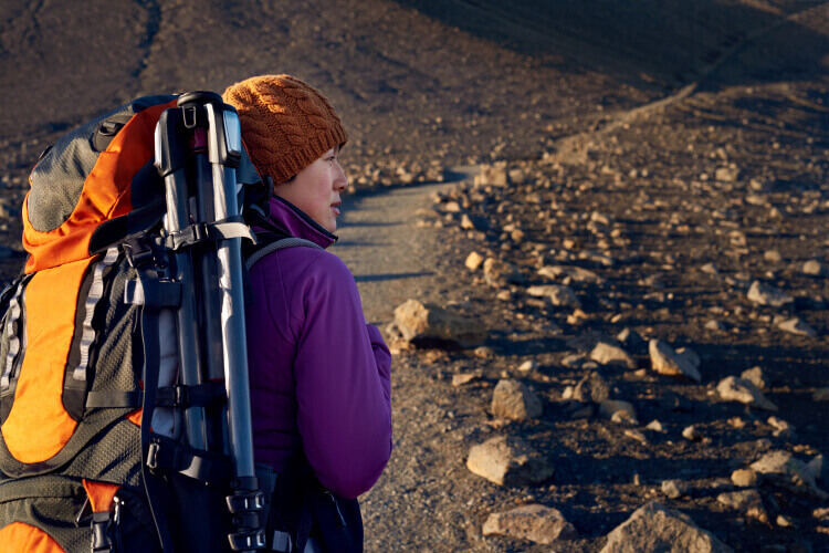 Hiking with tripod attached to backpack