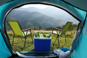 Chairs And Camping Fridge With Bottles Outside The Tent