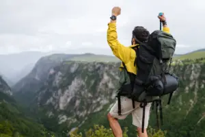 Man Wearing a Backpack is Hiking in the Mountains.